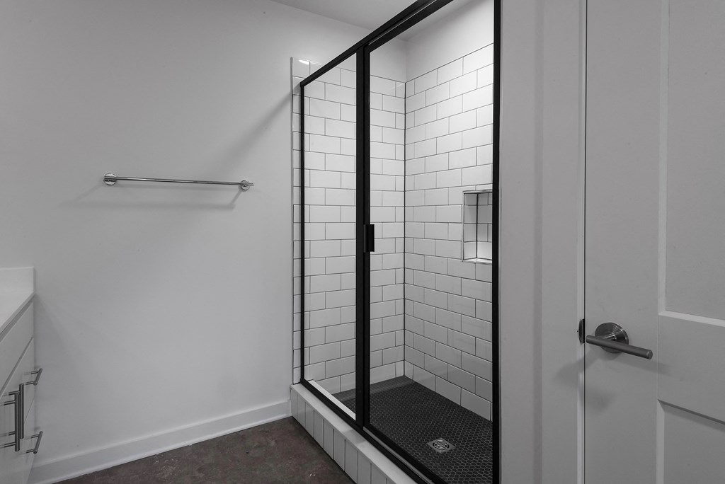 a black and white photo of a shower stall in a bathroom